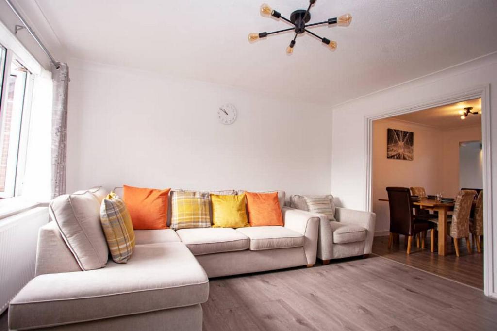 a living room with a couch and a ceiling fan at Cozy 3-Bedroom Home in Luton in Luton