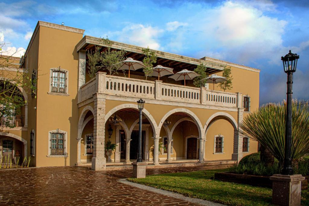 a building with a balcony with umbrellas on it at HC HACIENDA CATRINA HOTEL BOUTIQUE in Silao