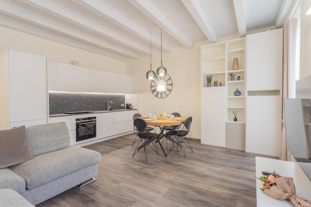 un soggiorno con tavolo e divano di Modern & Stylish Apartment in Como City by Rent All Como a Como