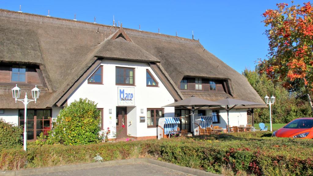 a large white house with a thatched roof at Mare Balticum Urlaub auf Rügen in Sagard