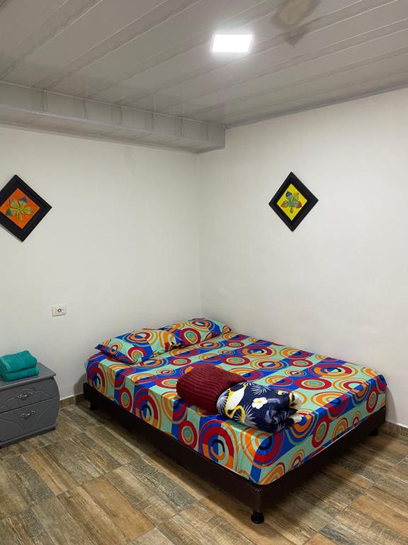 - une chambre avec un lit et une couverture colorée dans l'établissement Habitación independiente Baño exterior, à Armenia