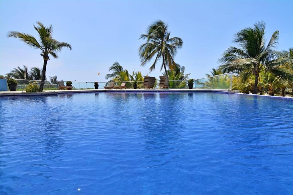 a large blue swimming pool with palm trees in the background at Apartamento de lujo en Morros Ultra in Cartagena de Indias