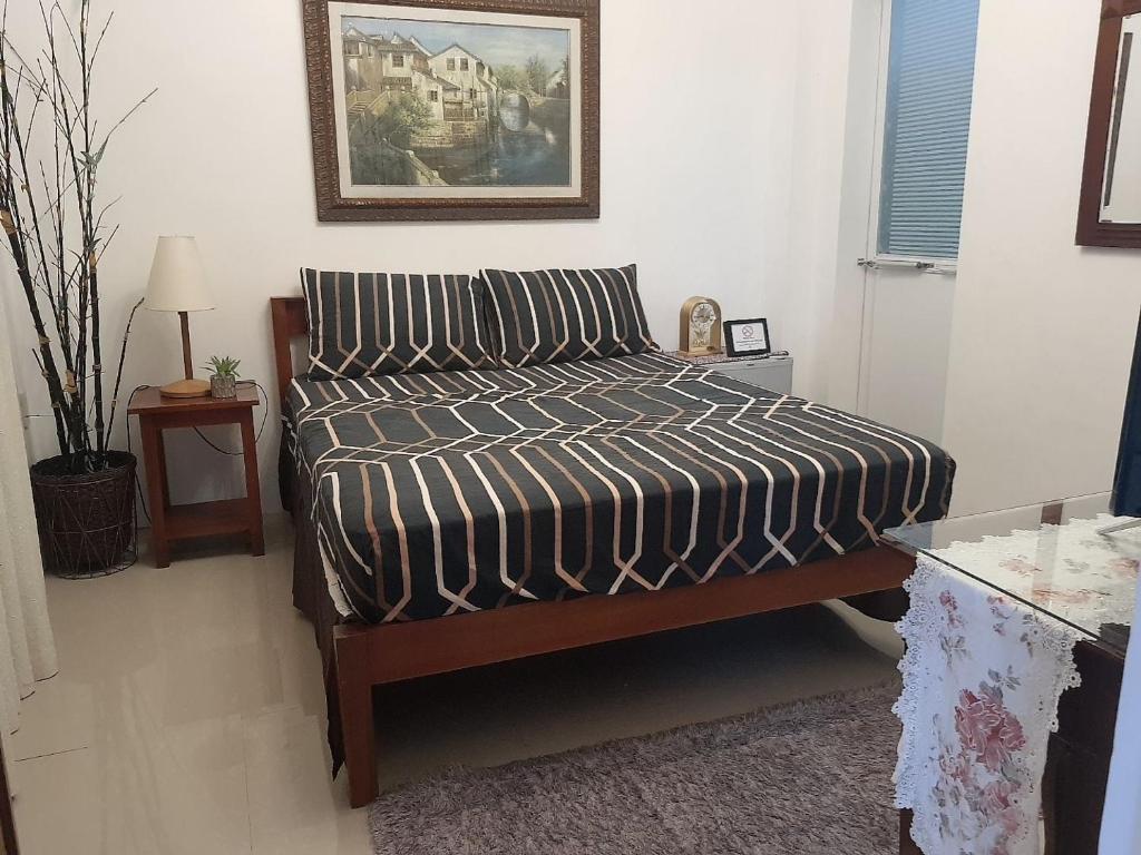 1 dormitorio con 1 cama con edredón blanco y negro en La Sierra Guest House, en Manbiga