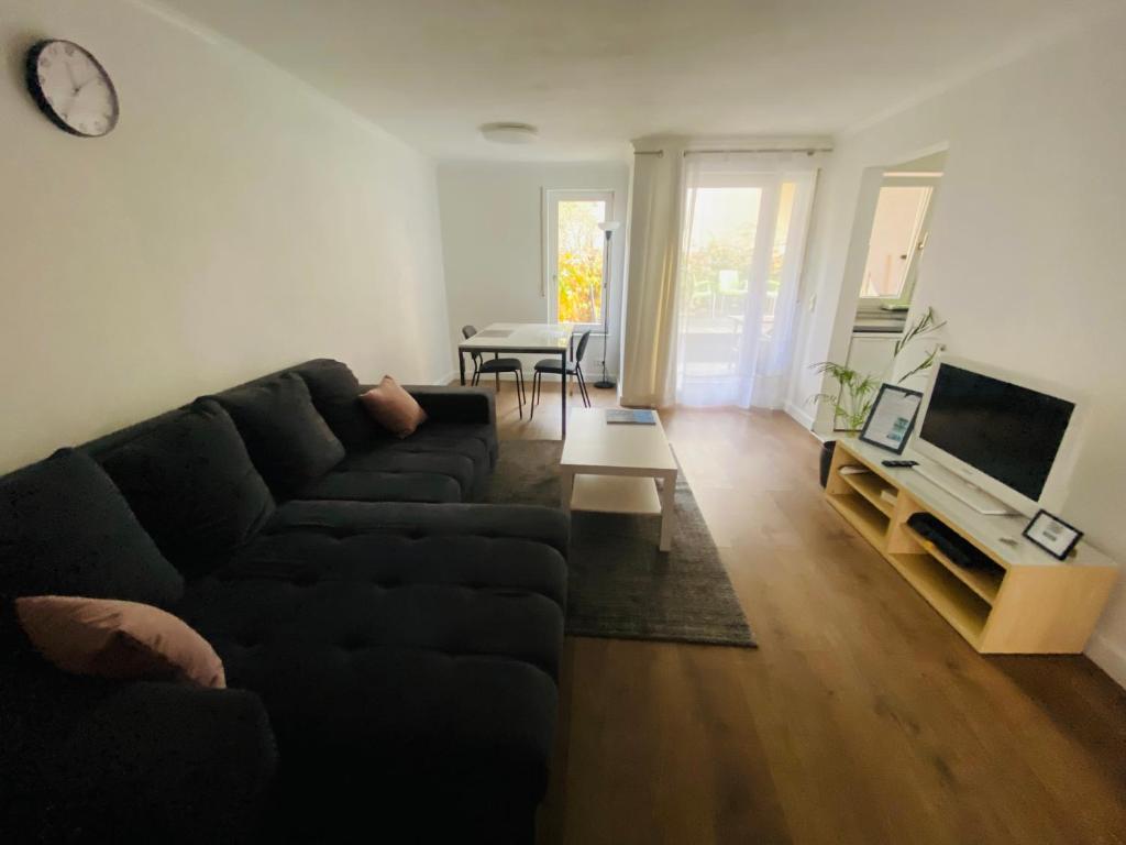 sala de estar con sofá negro y mesa en Exklusiv möblierte Wohnung in besten Lage, en Stuttgart