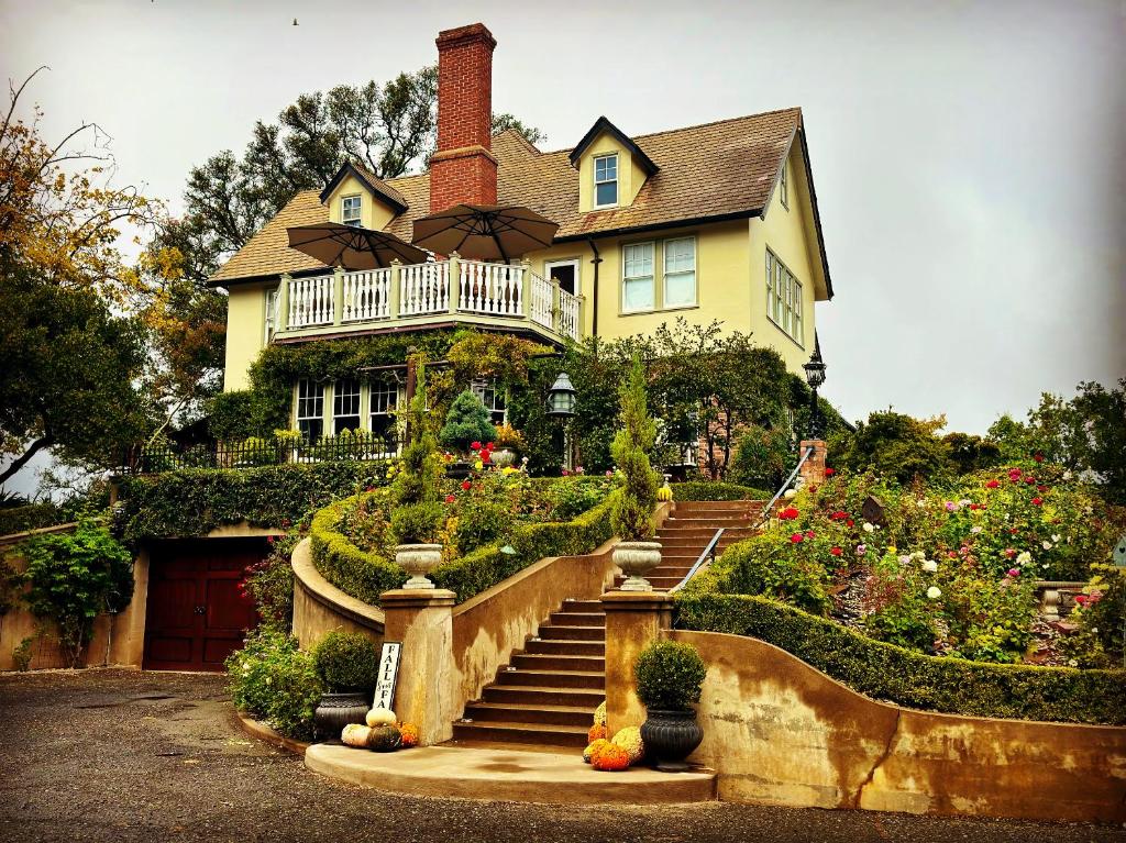 a yellow house with a staircase in front of it at The Inn on Knowles Hill Bed & Breakfast Hotel in Sonora