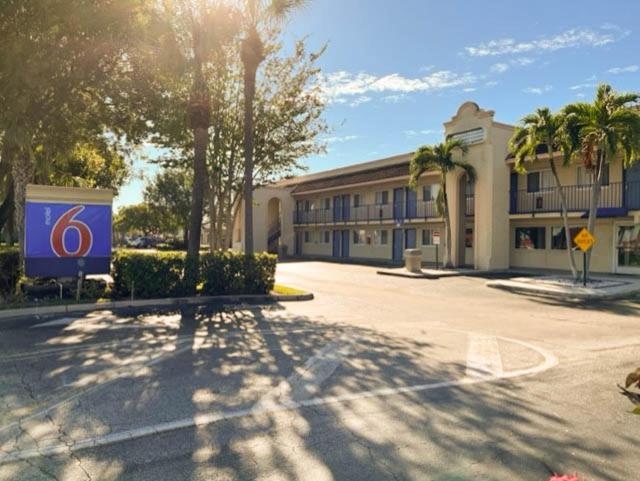 a building with a sign in the middle of a street at Motel 6 Riviera Beach FL in Riviera Beach