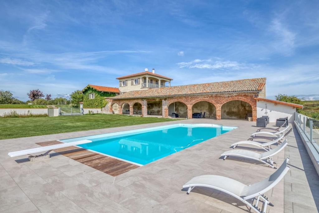 a swimming pool with chairs and a house at Family villa at 1H15 from Lyon in Prétieux