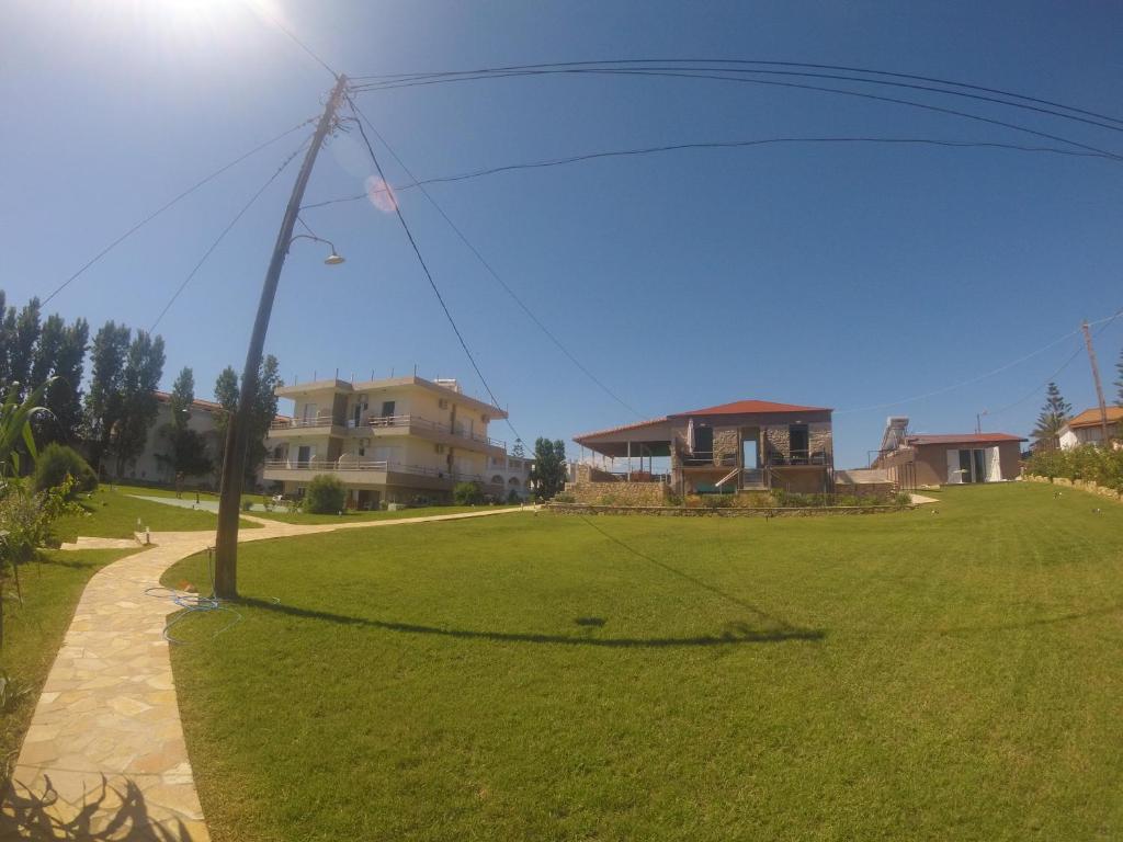 a grassy yard with a light pole and houses at Kimiro Drosia Zante in Psarou
