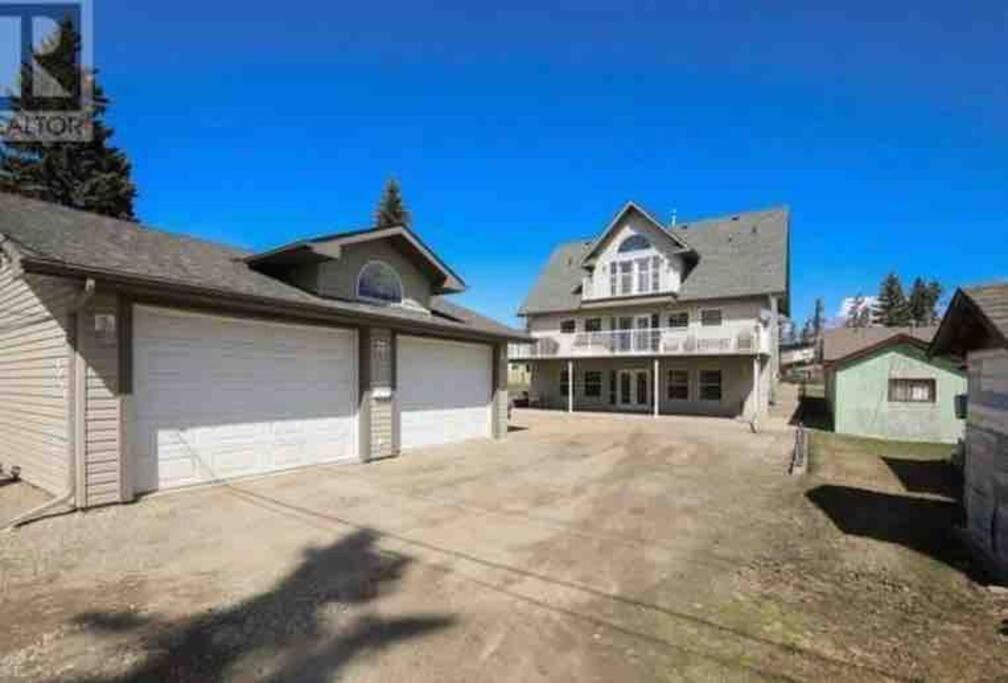 a large white house with a garage at Lakeshore Guest House - sleeps 18 in Sylvan Lake