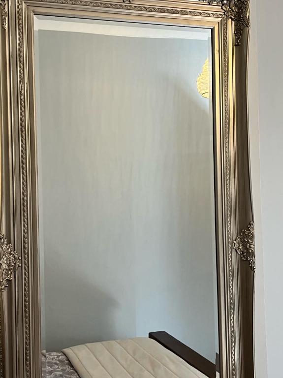 a mirror in a gold frame on a wall at Stone Lodge B&B in Balrath