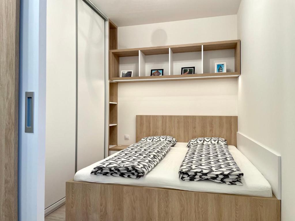 a bed in a small room with shelves at Explore Bratislava in Bratislava