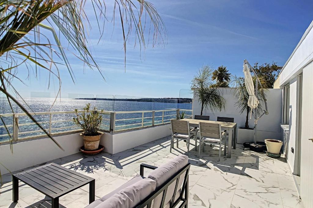 d'un balcon avec une table et des chaises et une vue sur l'eau. dans l'établissement REF 1769 - Cannes - Sea view penthouse for rent, à Cannes