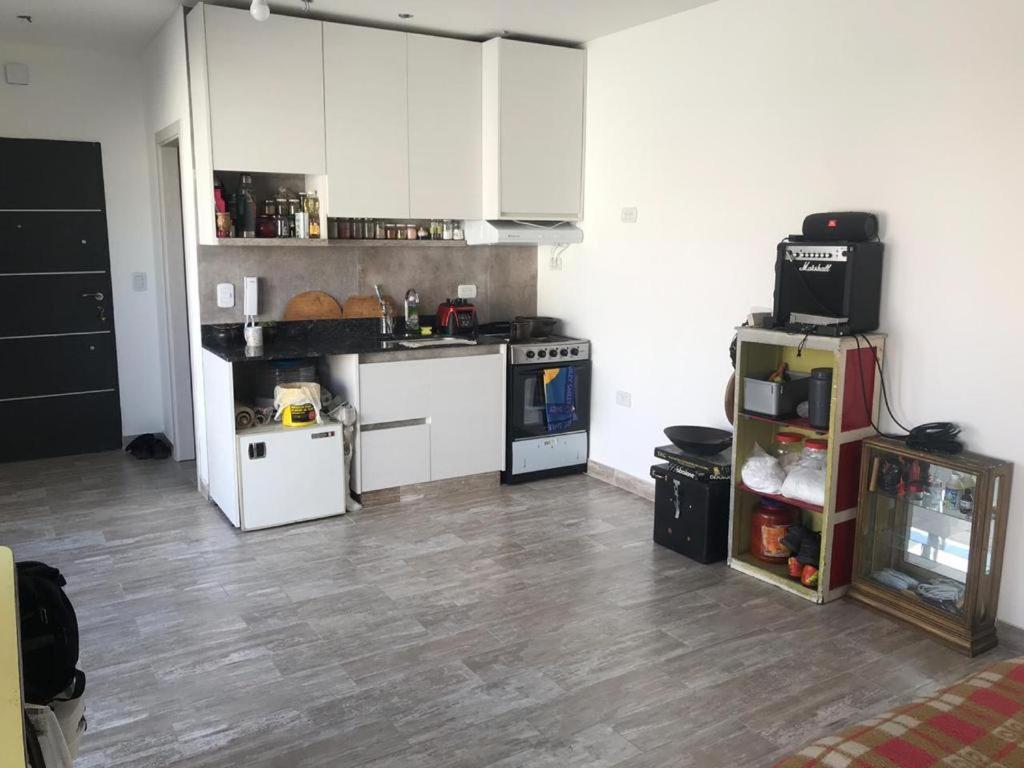 cocina con armarios blancos y suelo de madera en Casa Chai, con terraza, frente a Parque Sarmiento en Buenos Aires