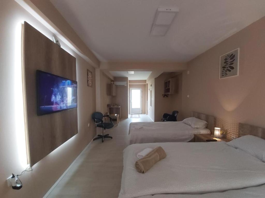a hotel room with two beds and a flat screen tv at Apartment KARADAK in Kriva Palanka