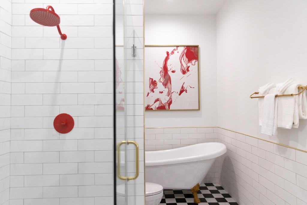 a bathroom with a tub and a toilet and a shower at The Vendue, Downtown Art Hotel in Charleston