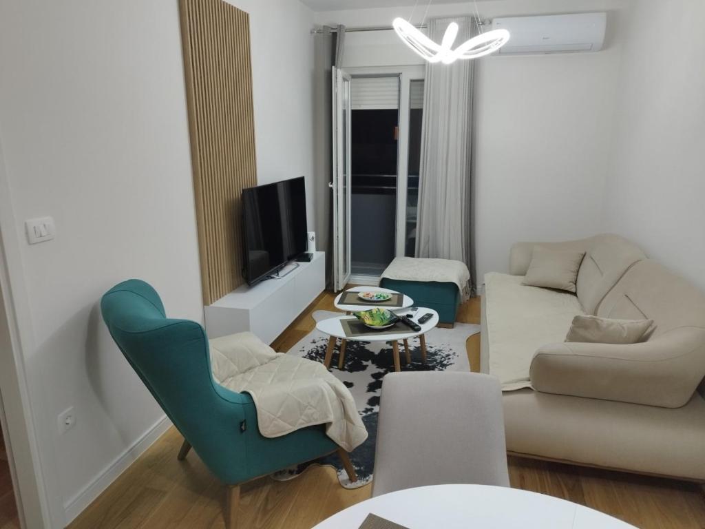 ein Wohnzimmer mit einem Sofa und einem Tisch in der Unterkunft Mia Apartments in Podgorica