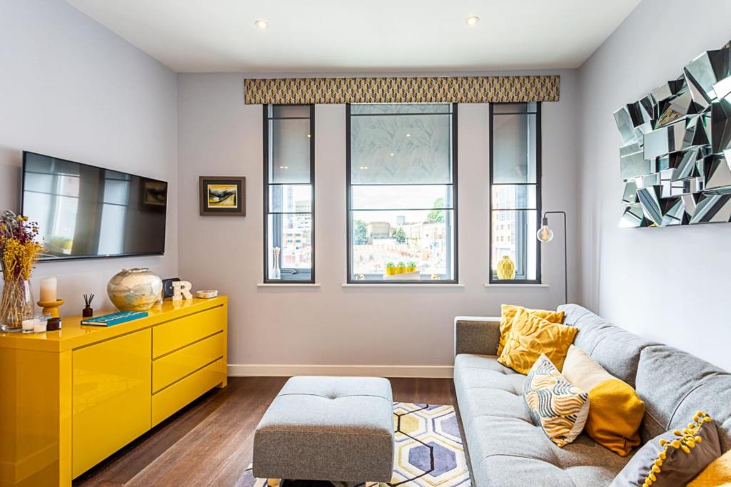 a living room with a couch and a yellow dresser at Exmouth Market Apartment in London