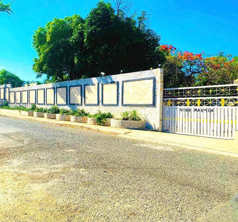 a white fence on the side of a road at Villa Marcia in Boca Chica