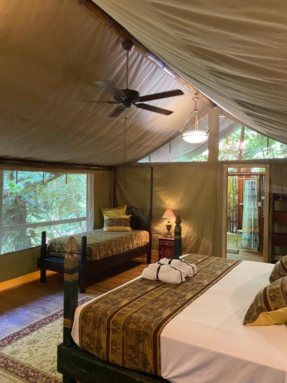a bedroom with two beds and a ceiling fan at Colina Secreta - Glamping and Villas in Puerto Viejo