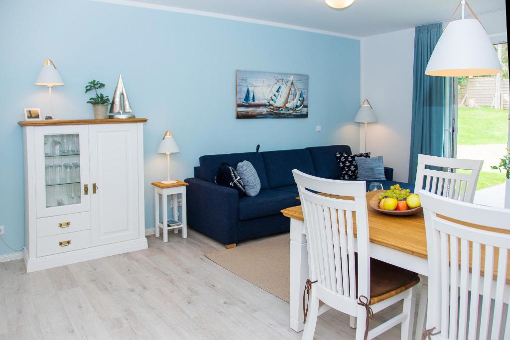a living room with a blue couch and a table at Cottage im Gutspark, Perlie - Komfort trifft maritimes Flair in Rerik