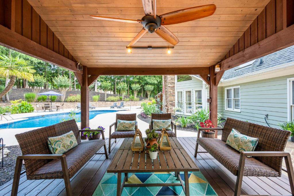 a patio with a ceiling fan and chairs and a pool at Relax In Private Pool & Cozy Gazebo At Param Farms in Cartersville