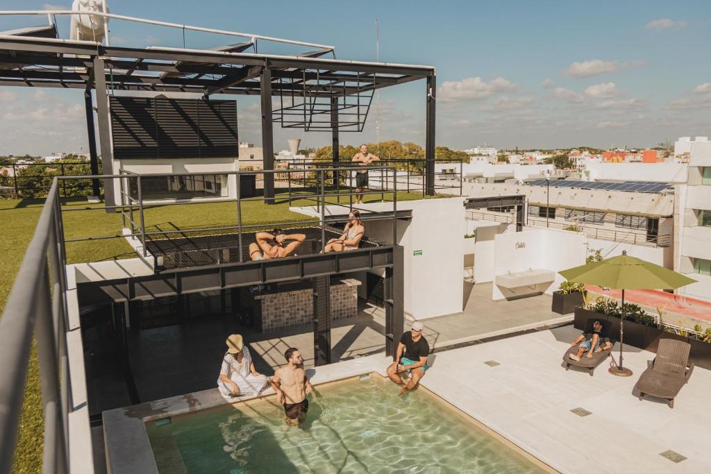 un grupo de personas en la piscina en la azotea de un edificio en Caleta Hostel Rooftop & Pool, en Cancún