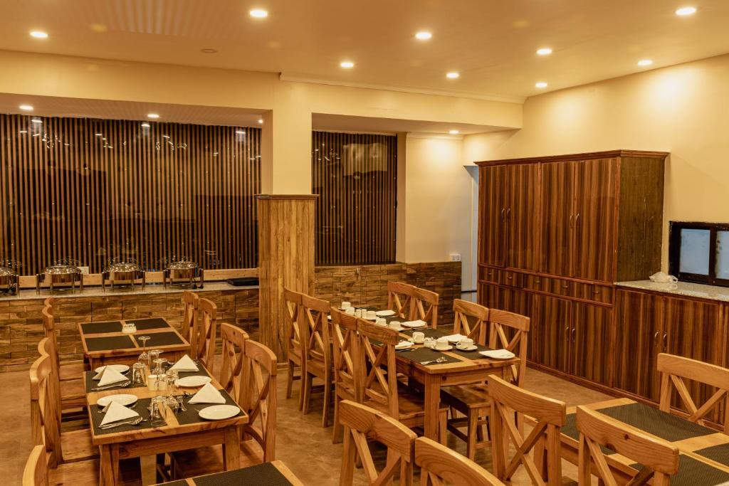 博卡拉Hotel Fewa Camp的用餐室配有木桌和椅子