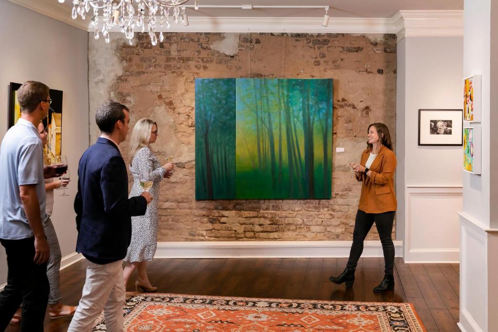 a group of people looking at a painting in a museum at The Vendue, Downtown Art Hotel in Charleston