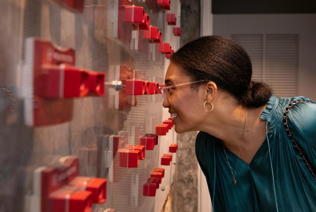 a woman looking at a wall of red boxes at The Vendue, Downtown Art Hotel in Charleston