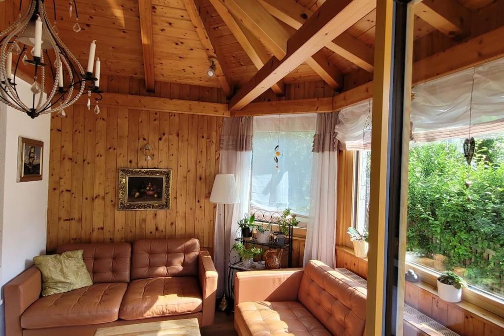een woonkamer met een bank en een raam bij Wohnung mit Garten, Sauna und Infrarotkabine 