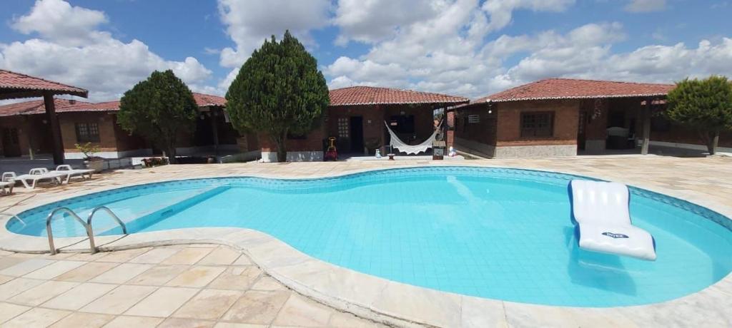 a large swimming pool with chairs in a courtyard at Casa chalé Gravatá in Gravatá