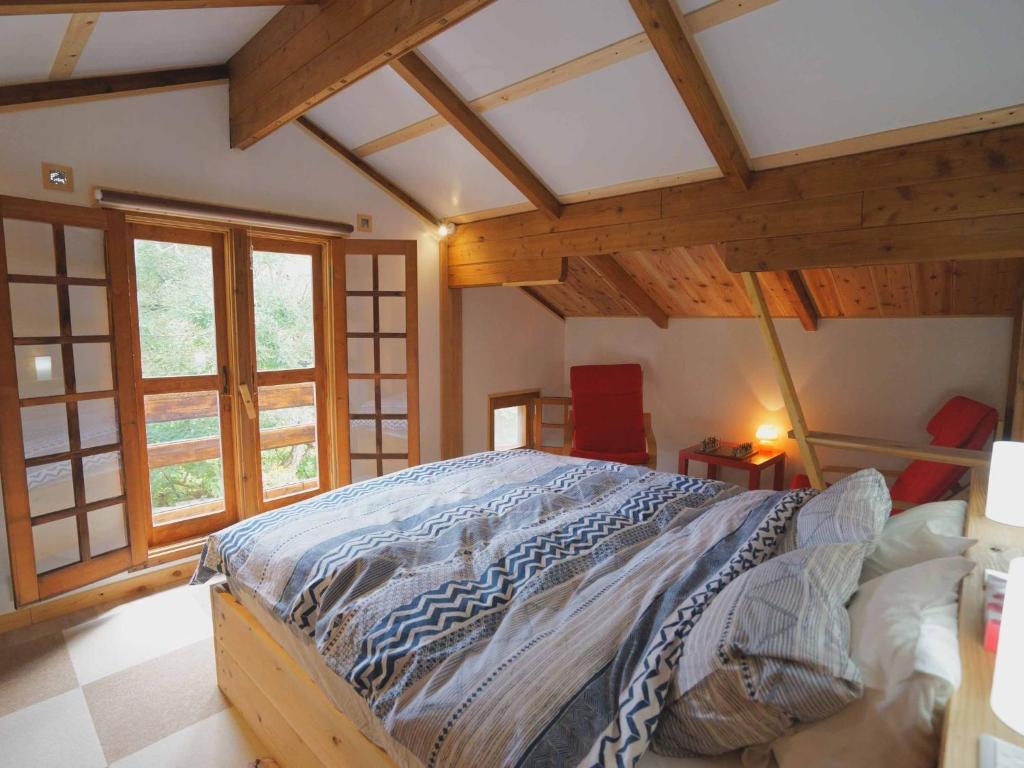 - une chambre avec un grand lit dans une pièce dotée de plafonds en bois dans l'établissement Alpages - Vacation STAY 11100, à Myōkō