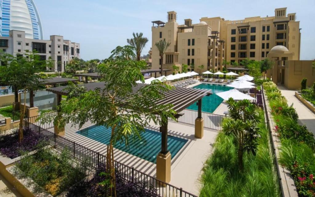 an overhead view of a pool with palm trees and buildings at Madinat Jumeirah Living One bedroom apartment in Dubai