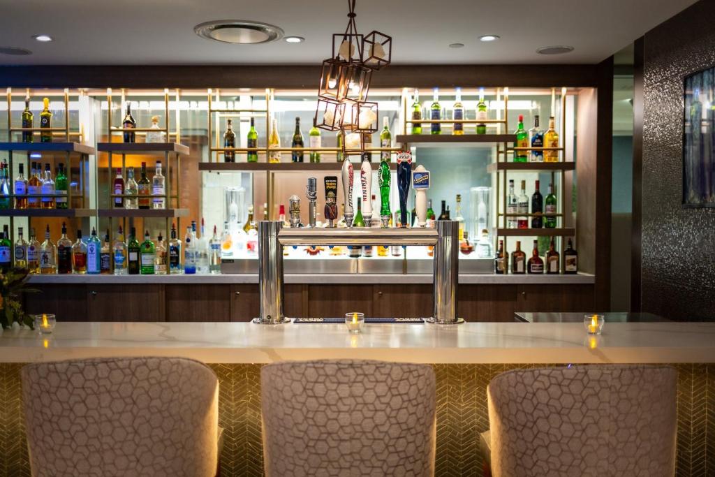 a bar with chairs in front of a counter with alcohol at Holiday Inn Toronto Downtown Centre by IHG in Toronto