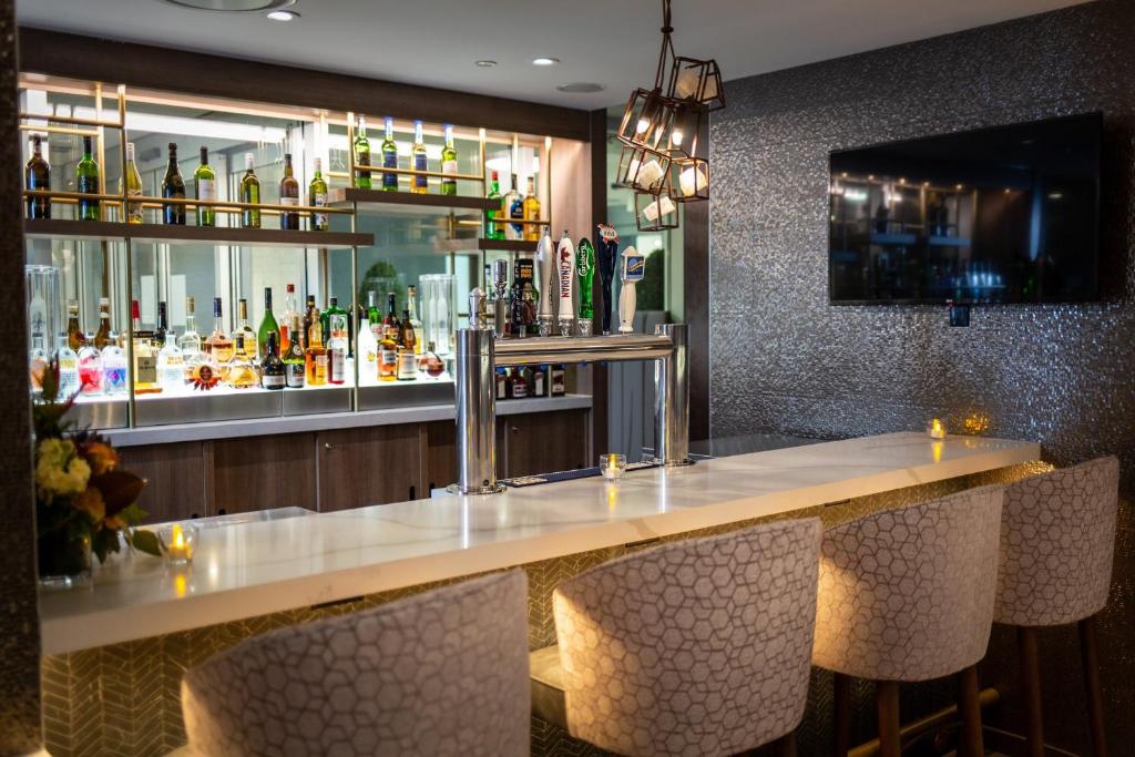 a bar in a restaurant with a counter and chairs at Holiday Inn Toronto Downtown Centre by IHG in Toronto