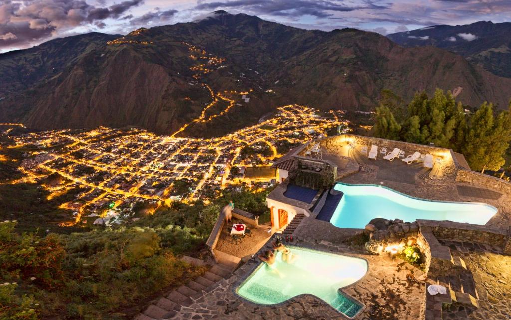 an aerial view of a villa with a swimming pool on a mountain at Luna Volcán, Adventure SPA in Baños