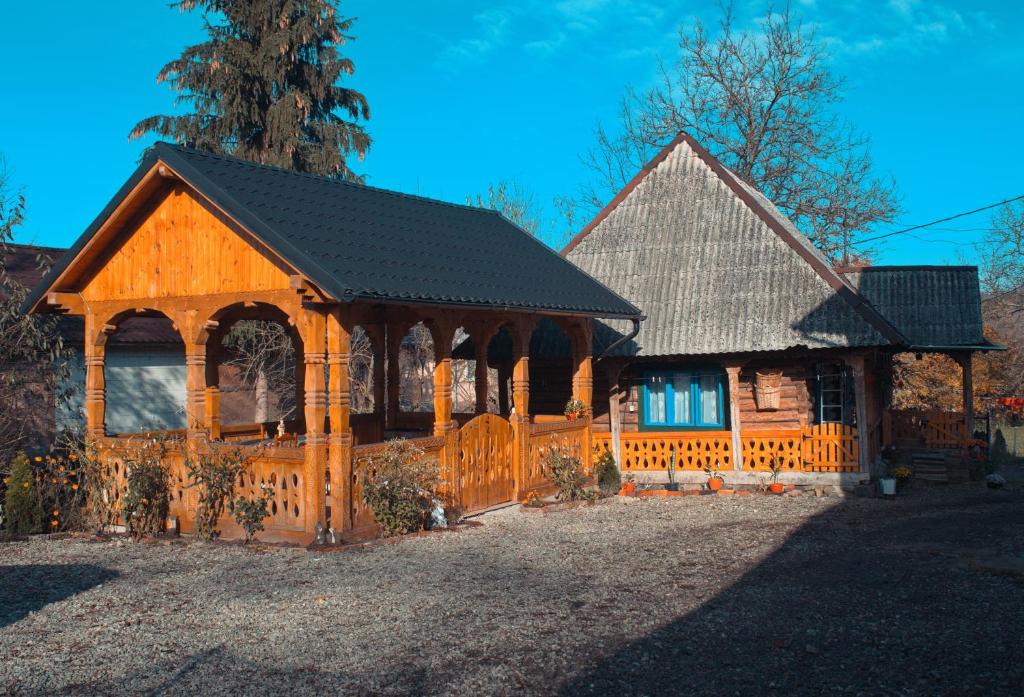 una casa in legno con cancello e recinzione di La Rodica in Vale a Ocna Şugatag