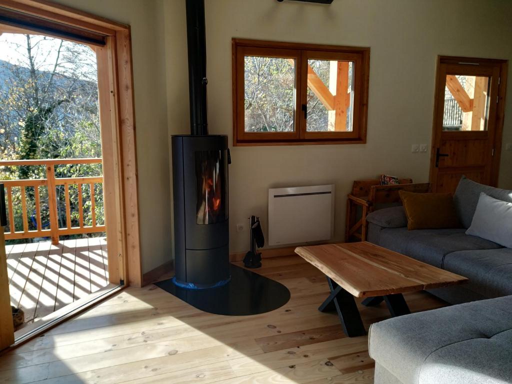 a living room with a fireplace and a couch and a table at CHALET ARLETTE in Les Orres
