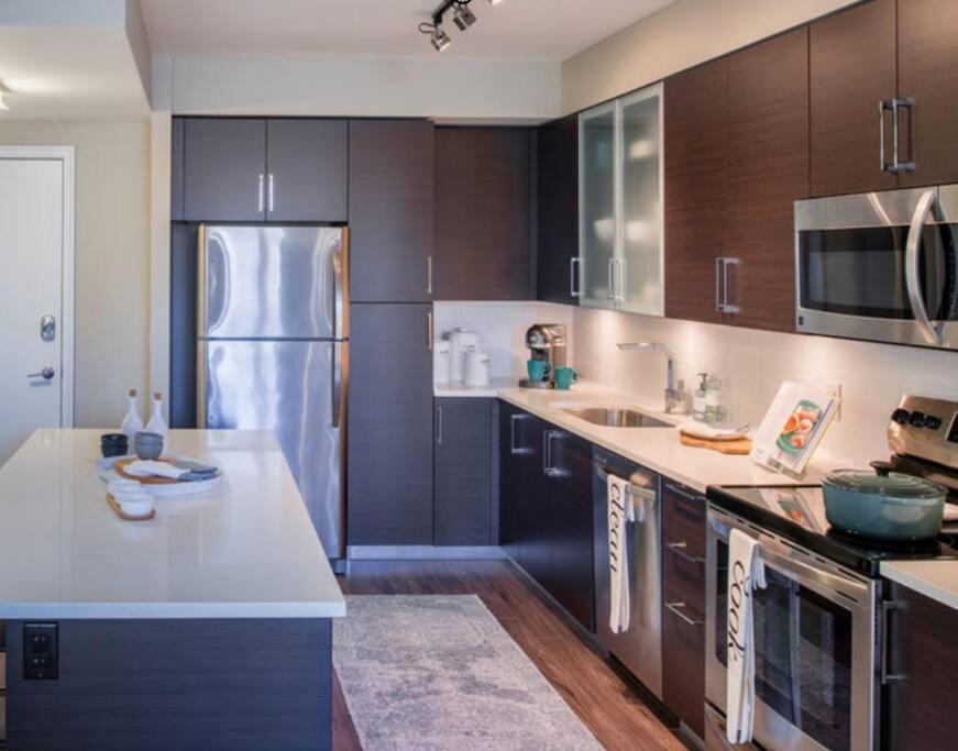 a kitchen with a stainless steel refrigerator and wooden cabinets at National at Pentagon in Arlington