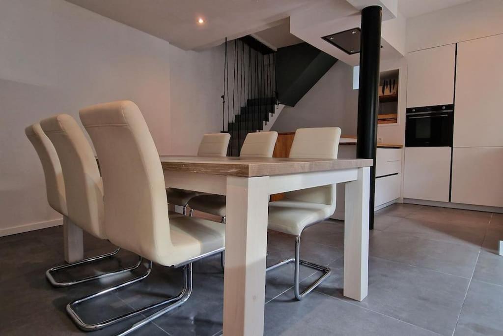 einen Esstisch und Stühle in der Küche in der Unterkunft Maison dans un des plus beaux villages de Wallonie in Gesves