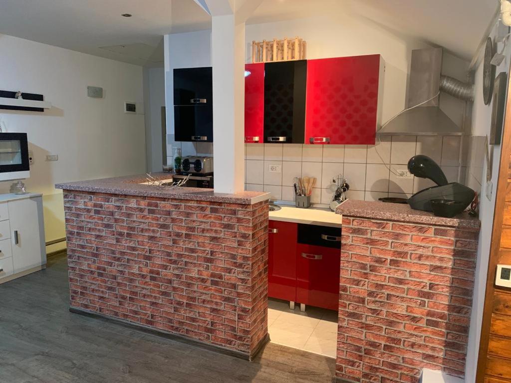 a kitchen with red cabinets and a brick counter top at Apartament in regim hotelier in Timişoara