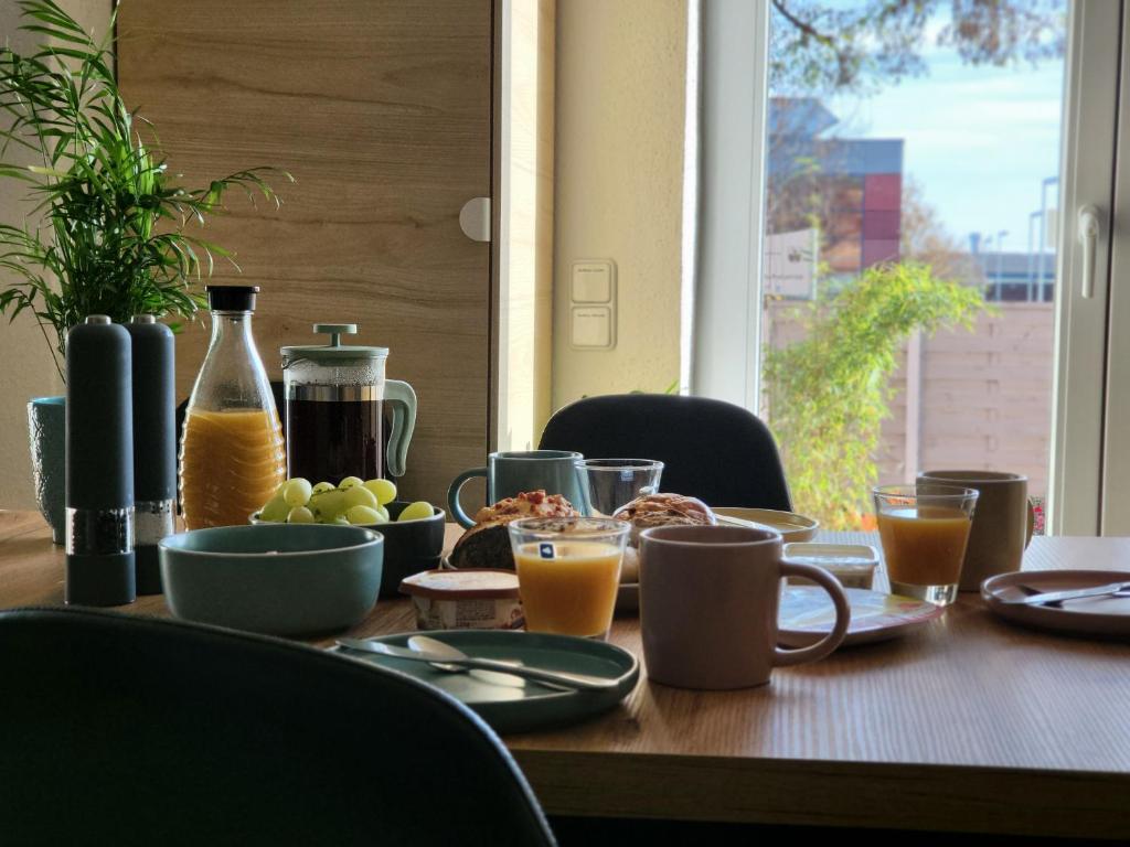 einem Holztisch mit Essen und Orangensaft darauf in der Unterkunft Modernes behagliches Haus mit Kamin, Terrasse und Garten in Magdeburg