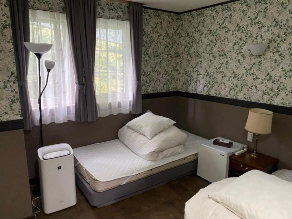 um pequeno quarto com 2 camas e uma janela em Ashigarashimo-gun - Hotel - Vacation STAY 53658v em Onsensō