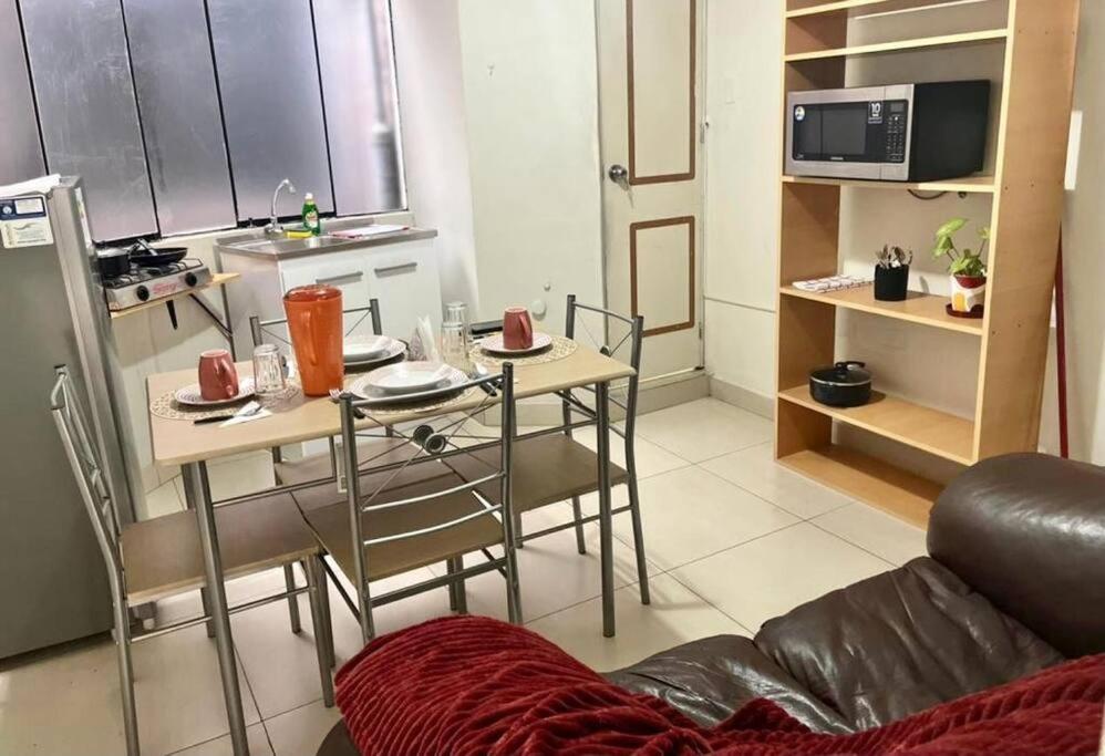 una pequeña cocina con mesa y sillas en una habitación en Lindo y Céntrico MiniDepartamento I, en Trujillo