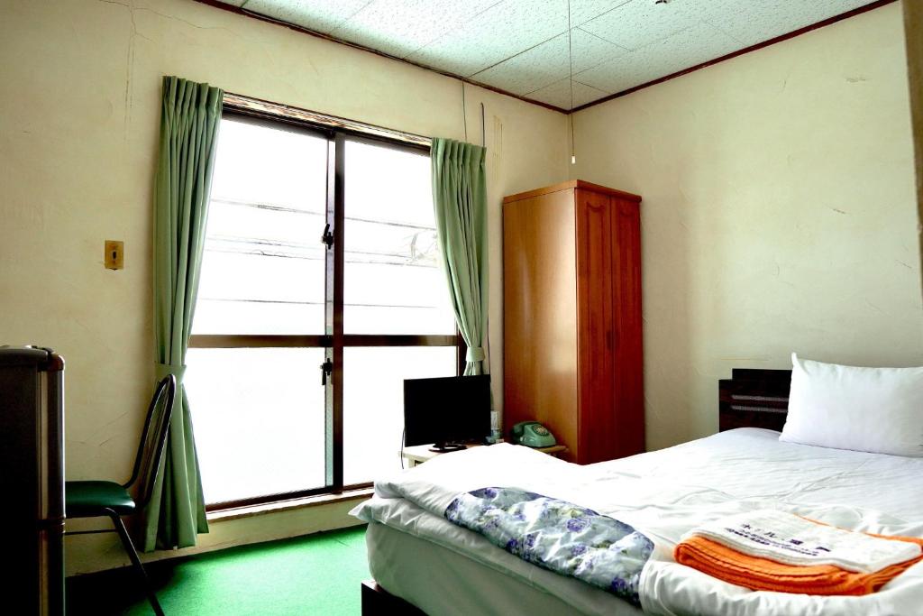 1 dormitorio con cama y ventana grande en Hotel Shiosai - Vacation STAY 68131v en Uruma