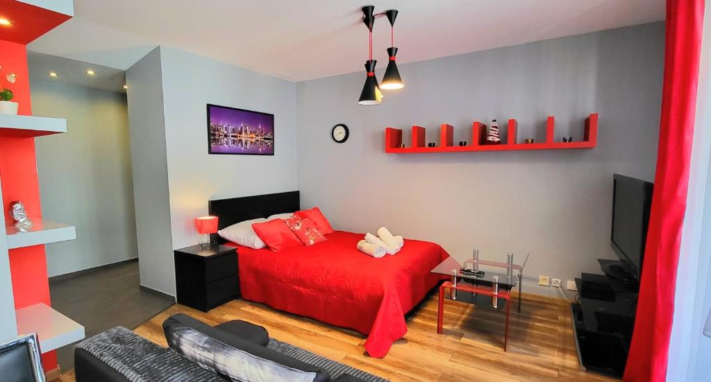 - un salon avec un lit rouge et un canapé dans l'établissement APARTMENT LUXURY OASIS Śródmieście DOWNTOWN 3 os, à Cracovie
