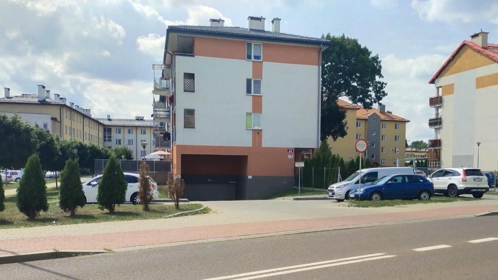 ein Gebäude an der Seite einer Straße mit geparkten Autos in der Unterkunft Apartament na Brudzewskiego in Przemyśl