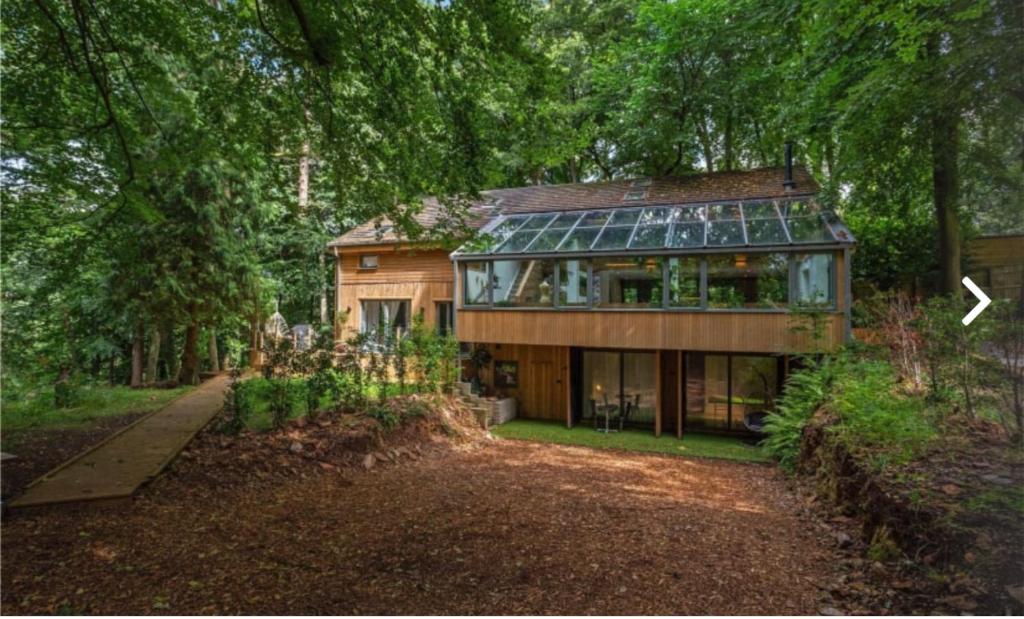 ein Haus mit Glasdach im Wald in der Unterkunft 5 Star Luxury Woodland Retreat Sleeps 12 Hot tub Sauna in Clapton in Gordano