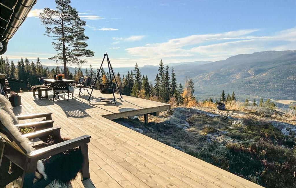 une terrasse en bois avec une table et une balançoire dans l'établissement 3 Bedroom Pet Friendly Home In Eggedal, à Eggedal