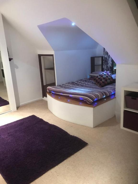 sypialnia z łóżkiem z fioletowym dywanem w obiekcie Top floor in beautiful home w mieście Radipole